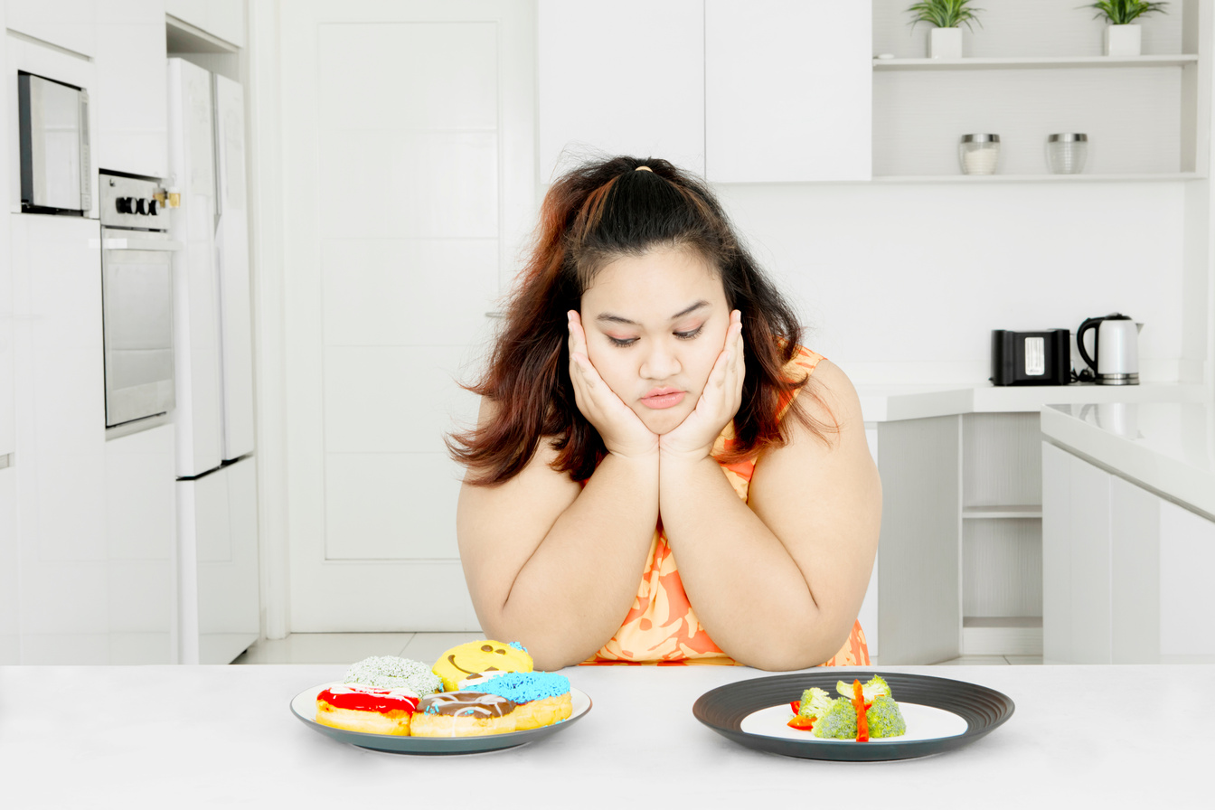 Plus Size Woman Staring at Donuts and Vegetable Salad